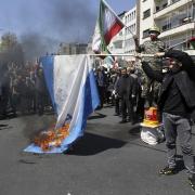 Iranian demonstrators burn a representation of the Israeli flag in Tehran