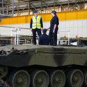Defence Secretary Grant Shapps stands atop a Challenger 3 tank prototype being built by BAE Systems