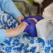 A care worker holing a patients hand during Covid-19