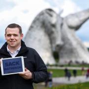 Douglas Ross holds a tablet with the words 'Sack Matheson' during a campaign visit to the Kelpies on Monday