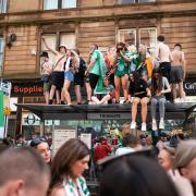 Celtic fans on top of a bus shelter in Trongate in Glasgow last month