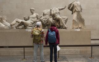 Visitors admire the sculpture of the ancient Greek Parthenon Marbles in the British Museum