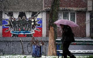 A pedestrian walks past a defaced mural to the glory of Russia's mercenary group Wagner