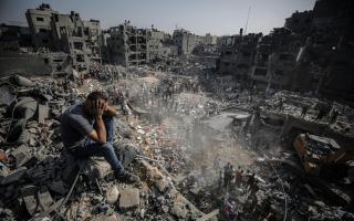 A man, sitting on debris, reacts as Palestinians conduct a search and rescue operation after the second bombardment of the Israeli army in the last 24 hours at Jabalia refugee camp in Gaza City