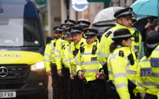 Police look on as climate protesters march though the City of London.