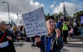 A protester is seen holding a sign to protest Trident and the bases of nuclear capable submarines (Photo: Getty)