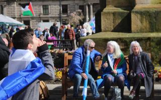 A young Yes supporter joins the chanting as older activists discuss the day