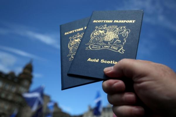 A pair of Scottish passports are held aloft during the March for Indy