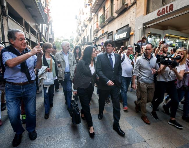 Catalan president Carles Puigdemont, who was officially deposed by Madrid, walks with his wife Marcela Topor in Girona on Saturday, October 28. Puigdemont called for 'democratic opposition' to direct rule imposed by the central government on the s