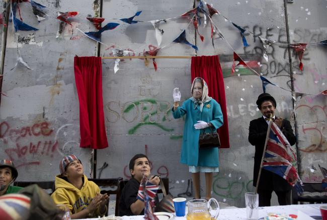 A Queen Elizabeth II impersonator joined Palestinian schoolchildren to unveil Banksy’s latest installation