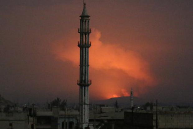 Smoke rises from the site of the attack in Hama, Syria